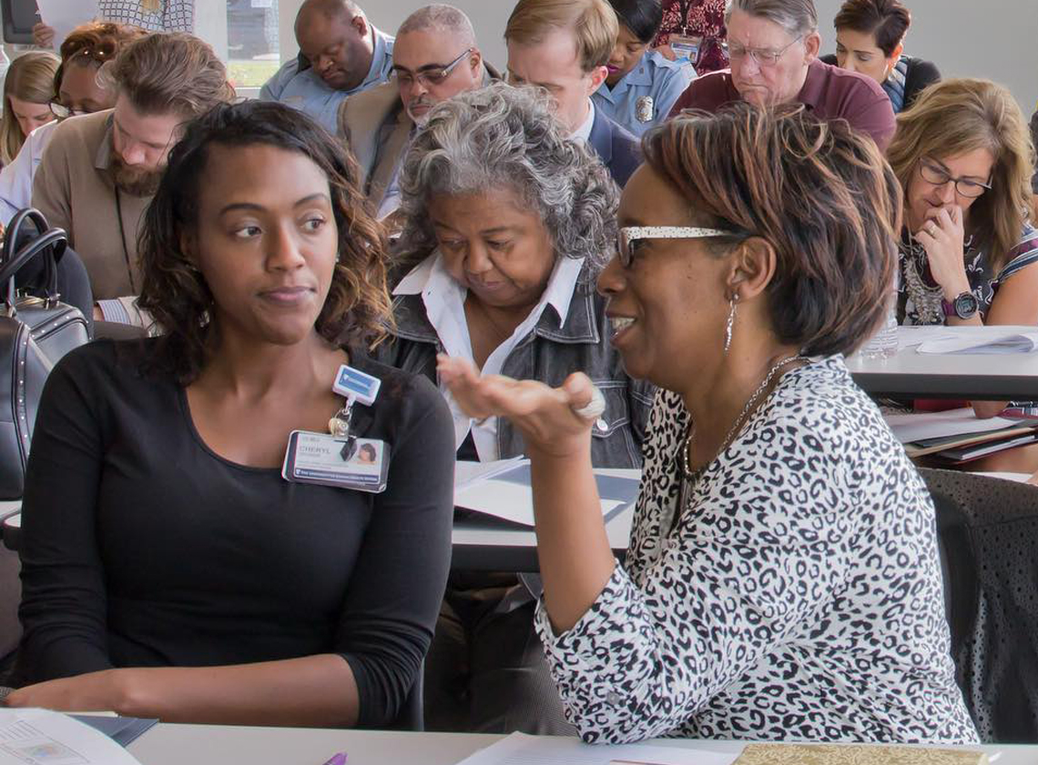 Two women talking at a REVIVE community meeting