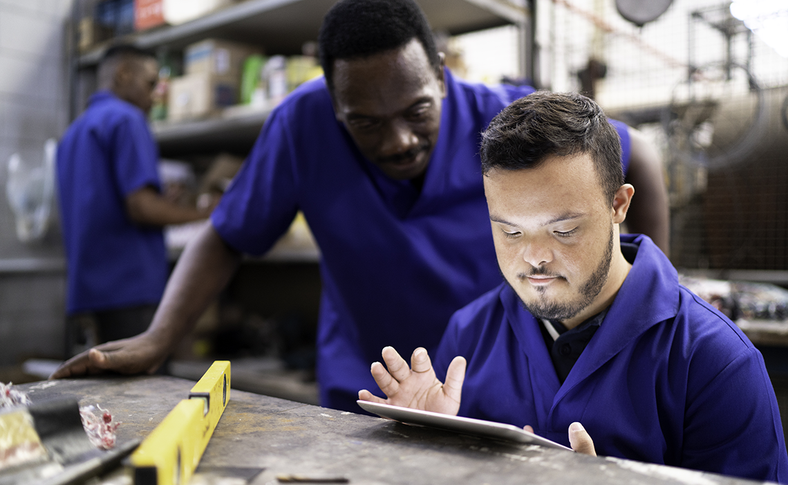 Two workers looking at a tablet screen