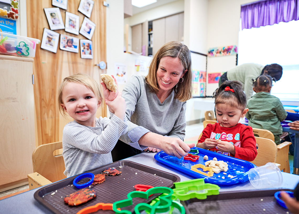 Children and teacher at table with toys